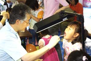 （写真）ファミリーコーナーで歯科健診を受ける女の子
