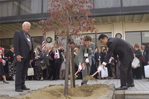 （写真）市民会館前でウォルトンスミス市長と久嶋市長が記念植樹を行う