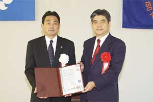 （写真）授与されたISO更新審査証を持つ久嶋市長（左）