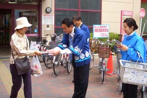 （写真）買い物客に広報物を手渡す久嶋市長