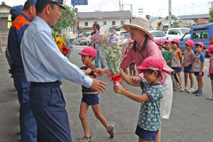 （写真）署員らに花束を渡す園児たち