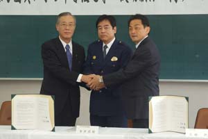 （写真）小田長岡京市長、寺井向日町警察署長と握手する久嶋市長
