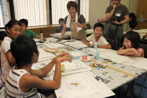 （写真）笑顔で教室を楽しむ子どもたちと早川さん（写真中央）