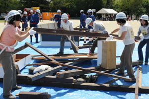 （写真）倒壊建物の下敷きになった人形の救出訓練を行う市民の方々