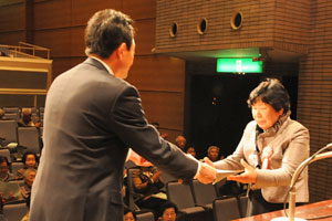 （写真）市長表彰を受ける鶏冠井町第1寿クラブの上田百子さん