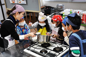（写真）雪印乳業株式会社の出前授業でチーズ作りを体験する4向小の児童