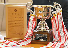 （写真）贈られた竹製の表彰状と、大会の優勝カップ