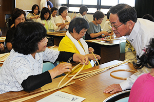 （写真）かごの編み方を習う参加者