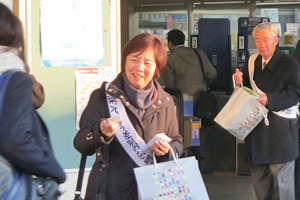 （写真）阪急東向日駅前で広報グッズを手渡す様子
