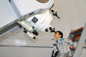 （写真）熱心に望遠鏡をのぞく子ども