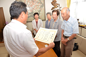 （写真）久嶋市長から感謝状を受け取るシンポクラブの越智進会長