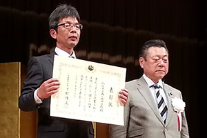 （写真）文部科学大臣表彰式の櫻田義孝文部科学副大臣と藤井真次西ノ岡中学校校長
