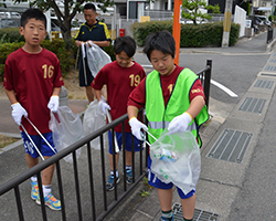 （写真）空き缶を拾う小学生